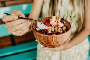 Bol de petit déjeuner minceur au yaourt grec, fruits rouges et graines de chia sur une table en bois