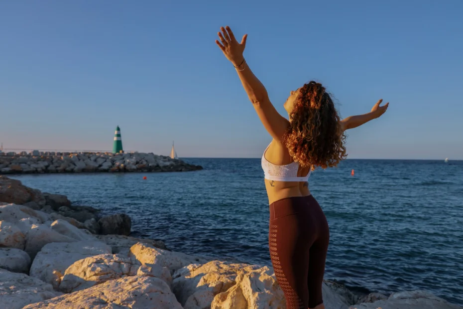 femme bras ouvert au bord de l'eau qui se détend
