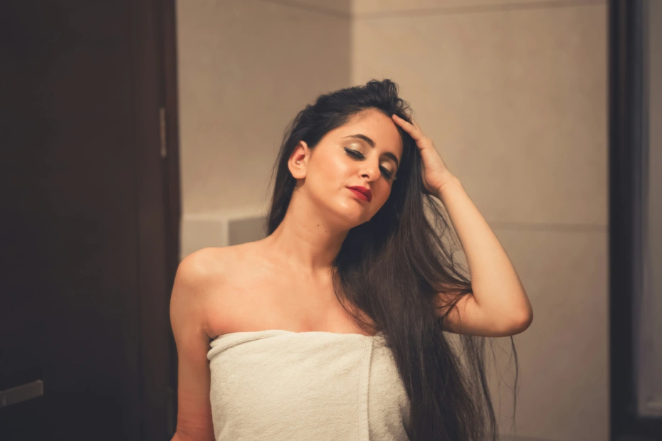 Femme se coiffant les cheveux avec mes mains, soin capillaire pour cheveux brillants et en bonne santé