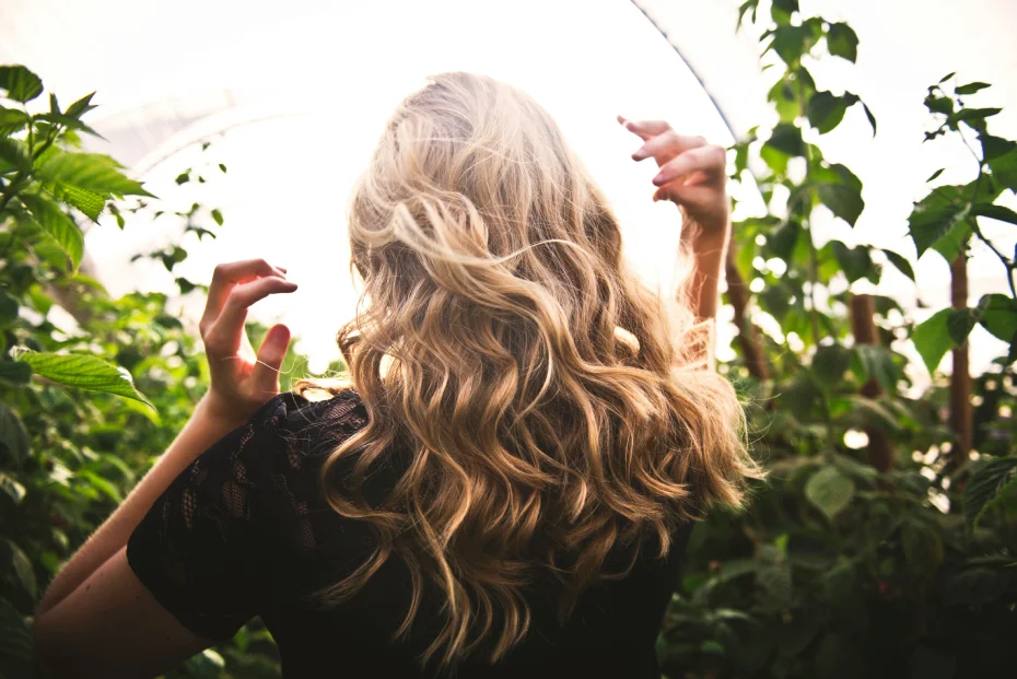 femme blonde vu de dos qui met ses mains dans ses cheveux